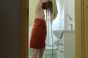 I ahead to from the next room as a young red-haired stepmother dries her hair with a hairdryer.